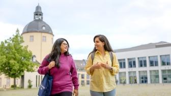 Studierende laufen über Schlossplatz am Campus US